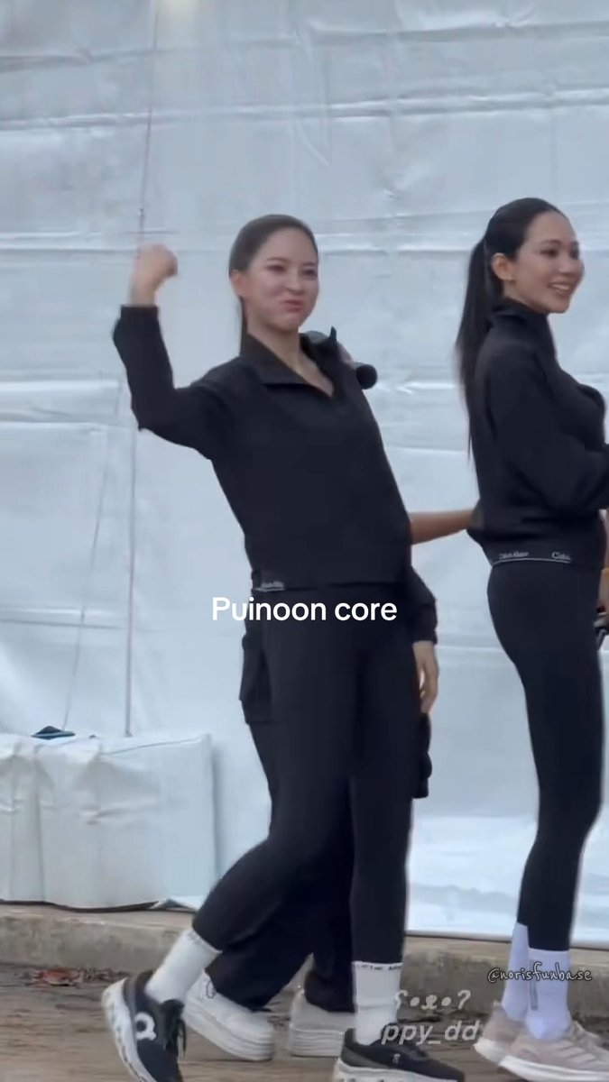 Two women in matching black athletic outfits walking together in what appears to be a behind-the-scenes setting, with text overlay reading 'Puinoon core.'