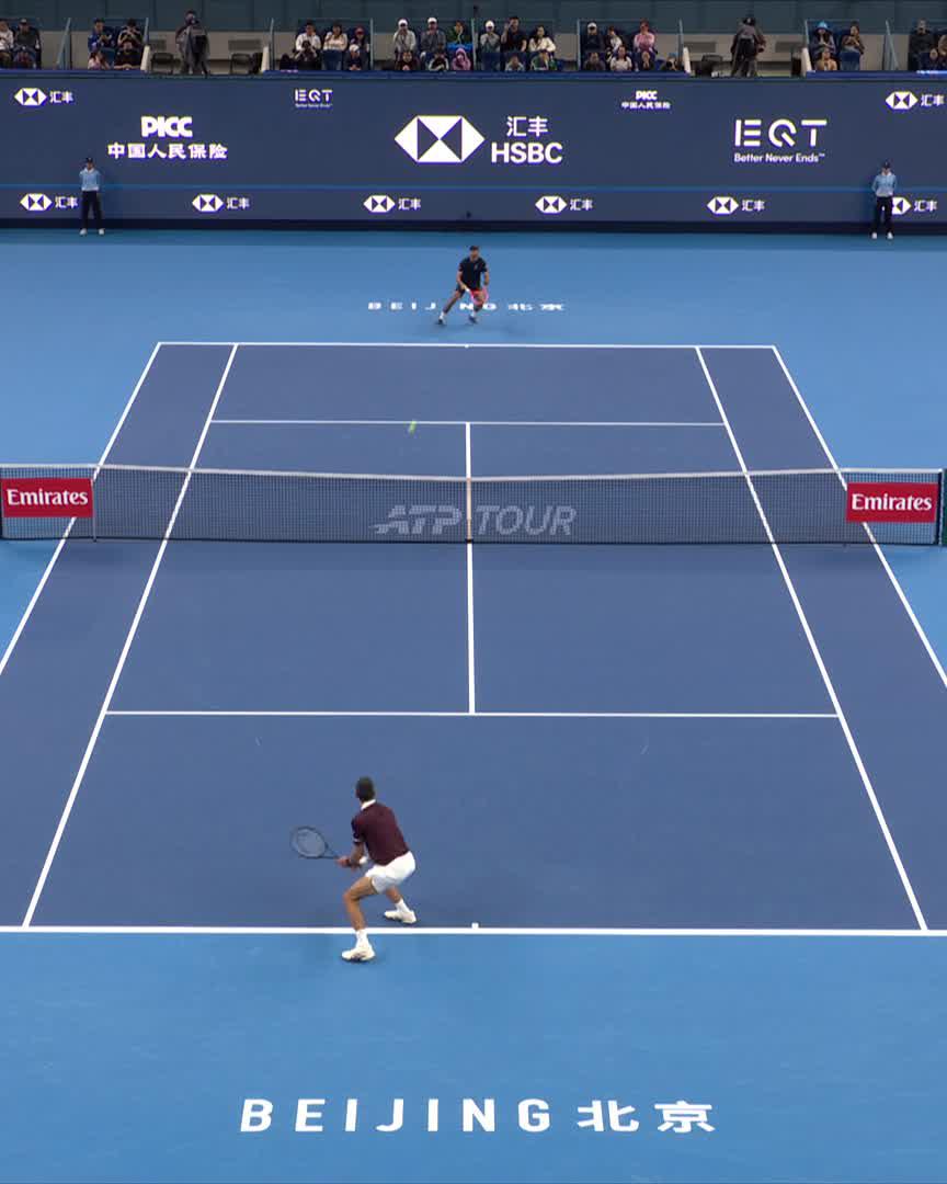 A tennis match at the China Open in Beijing (ATP Tour) shows a player at the baseline preparing to return a shot against an opponent near the service line, with HSBC, PICC, and Emirates sponsor banners visible around the court. The image illustrates the context of the post, capturing the moment of Djokovic's dominant 6-3 first set win over Borges.