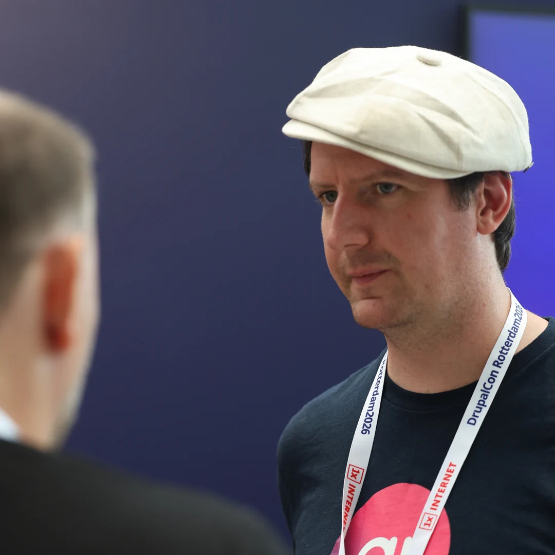 Dan Lemon in conversation with an attendee at the amazee.ai booth during DrupalCon Rotterdam 2026