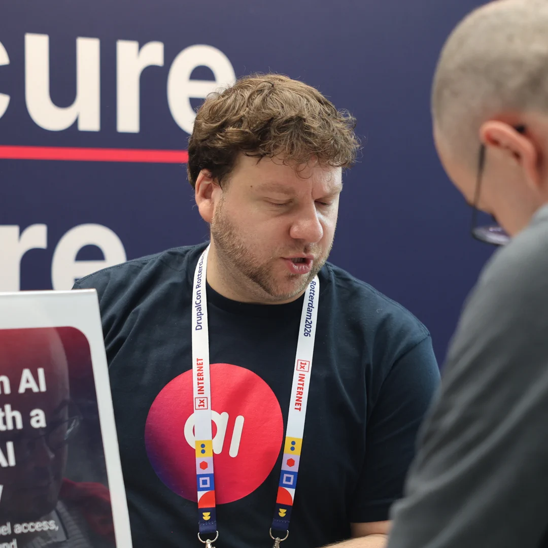 An amazee.ai team member engaging in a technical discussion with a visitor at the DrupalCon Rotterdam 2026 booth