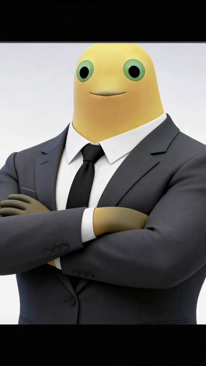 A 3D rendering of a yellow blob-like character with green eyes wearing a formal gray business suit with a white shirt and black tie, standing with arms crossed.