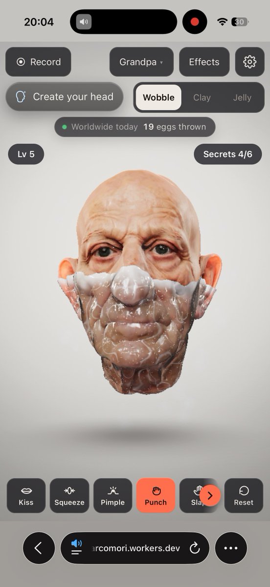 A screenshot of an iPhone displaying a 3D 'Grandpa' head wobbling effect on the website 'arcomori.workers.dev', with interface options for Kiss, Squeeze, Pimple, Punch, Slap, and Reset.