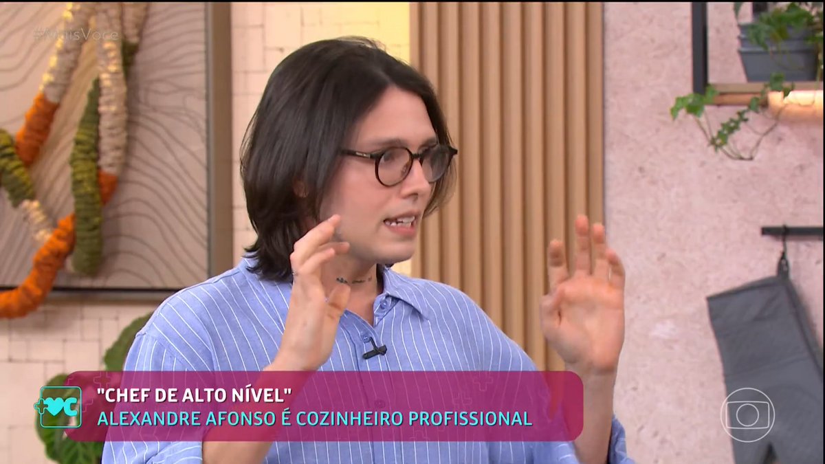 A Brazilian TV interview screenshot showing a person with glasses and a blue striped shirt gesturing while speaking; the lower third reads 'CHEF DE ALTO NÍVEL' - Alexandre Afonso é cozinheiro profissional on Mais Você.