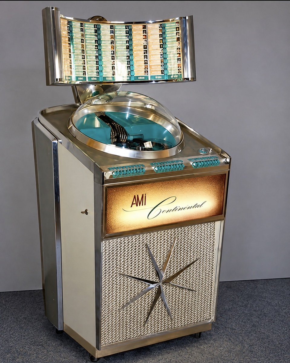 pastarchive's tweet photo. This futuristic jukebox was made in 1961.

The AMI Continental held 100 45-rpm records, giving listeners 200 song selections.

Its most distinctive feature was the curved, illuminated title display above a transparent dome that exposed the record-playing mechanism below.

Available in mono and stereo versions, the Continental became one of AMI’s most recognizable jukebox designs of the early 1960s.