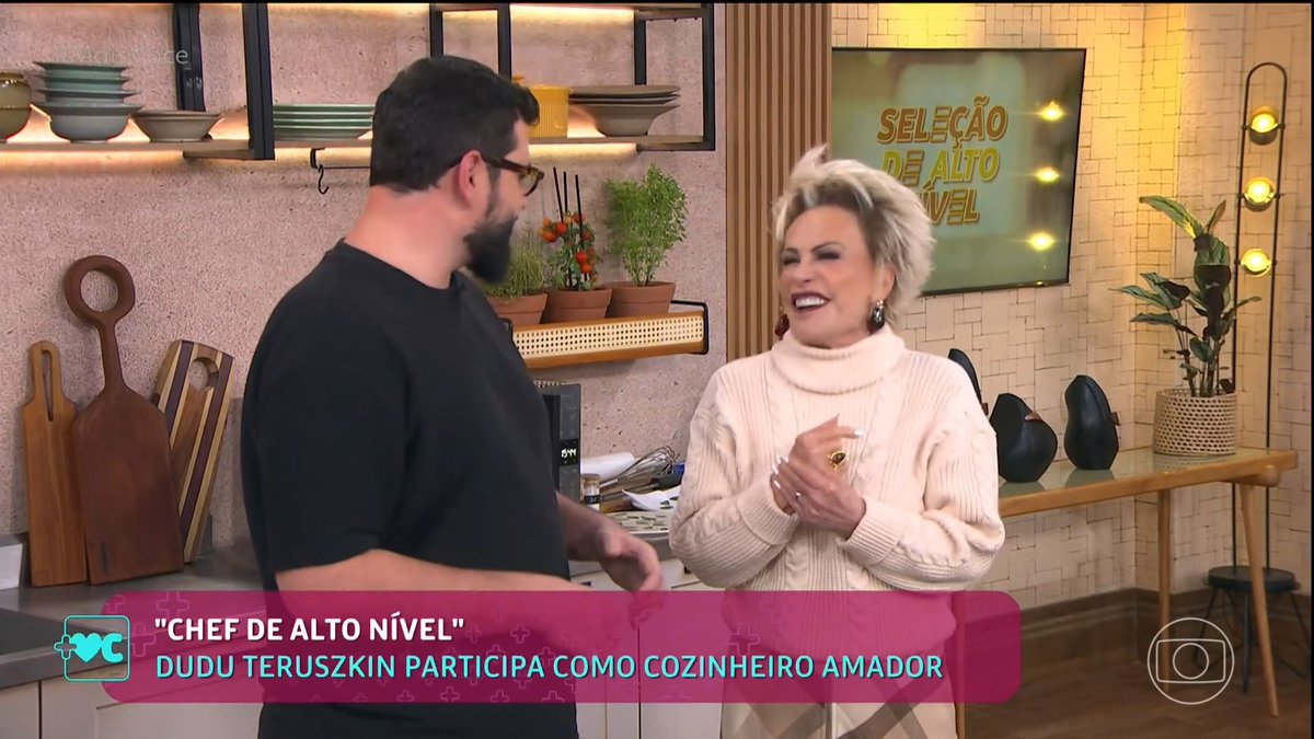 A smiling woman in a cream sweater laughs with bearded chef Dudu Teruszkin in a bright kitchen studio set, while an on-screen graphic reads "CHEF DE ALTO NÍVEL - DUDU TERUSZKIN PARTICIPA COMO COZINHEIRO AMADOR" alongside the "Seleção de Alto Nível" logo, matching the post about his appearance on the show.