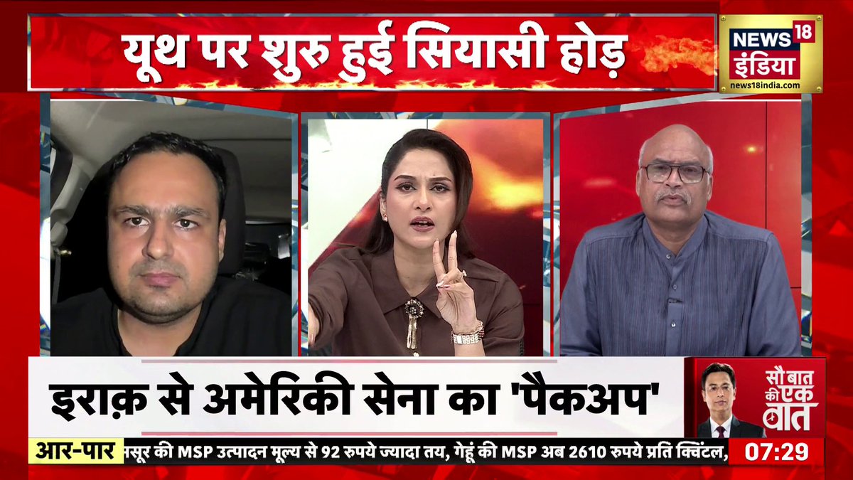 A News18 India television broadcast with the headline 'युध पर शुरू हुई सियासी होड़' featuring three people in a video panel, with a ticker reading 'इराक से अमेरिकी सेना का पैकअप' and timestamp 07:29.