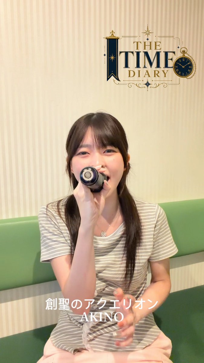 A young woman in a striped shirt and pink pants drinks from a bottle while sitting on a green couch; the logo 'THE TIME DIARY' appears above her and Japanese text '創聖のアクエリオン AKINO' is overlaid at the bottom.