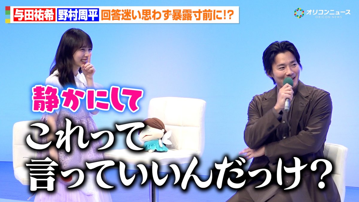 At a press event for Yuki Yoda and Shuhei Nomura, the two actors share a lighthearted moment on stage, with Yoda giggling and Nomura speaking into a microphone, as large Japanese subtitles read "静かにして これって言っていいんだろうけ？" ("Quiet! Is it okay to say this?").