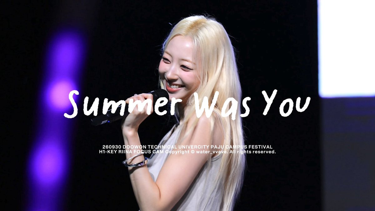 A blonde woman smiles while holding a microphone at a performance, with text overlay reading 'Summer Was You' and '260930 DOOWON TECHNICAL UNIVERGITY PAJU CAMPUS FESTIVAL H1-KEY RIINA FOCUS CAM Copyright © water_vvave. All rights reserved.'