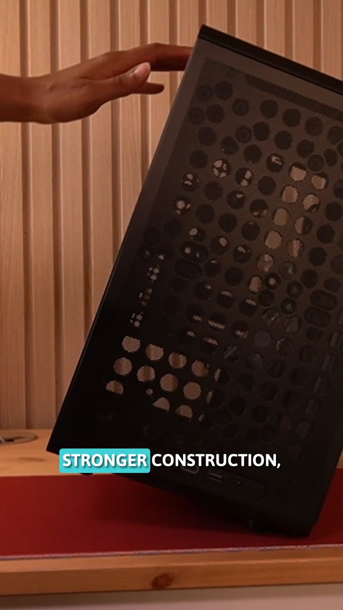 A hand tilts a black PC case with a perforated mesh panel, showcasing its sturdy build, while the text "STRONGER CONSTRUCTION," appears on screen, emphasizing the durability highlighted in the post about the Q300L V3's flexible and improved design.