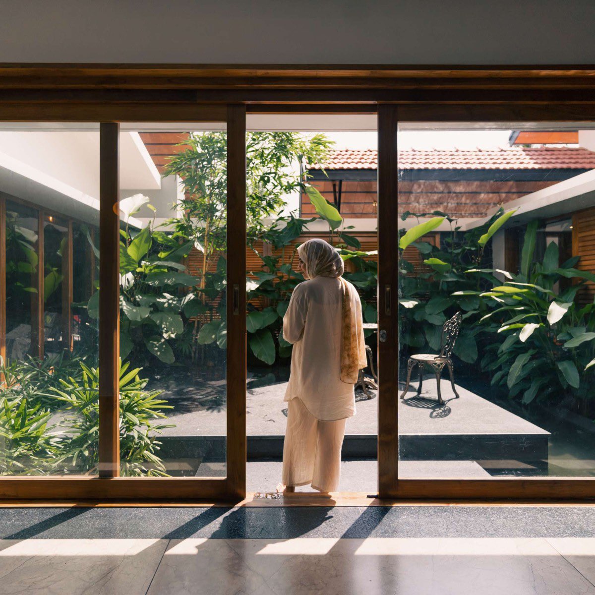 shavnyuyngah's tweet photo. Look at how many openings this house has, then ask why yours has so little.

HAYA sits in Wandoor, Kerala, built as a single storey around a central courtyard with a water feature at its heart. Big glass openings and wooden shutters run through the whole plan, so light pours in and every bedroom, including the master suite, looks out onto that courtyard instead of a blank wall.

The roof does real work too. Kerala clay tiles, no cornices, just a clean sloped line. That absence of ornament isn't a gap, it is restraint, and clay itself carries thermal mass that keeps the interior cooler through the day, the same climate logic we live under here.

This is built for the exact heat and humidity we deal with. So why do our own homes still get built with small windows and sealed-off rooms, in the same climate this house was designed to breathe in?

More images from this one are in the thread below.

Wandoor, Kerala, India. Architect: Farsa Buildesign. Completed 2023. Photography: Marc Frames.