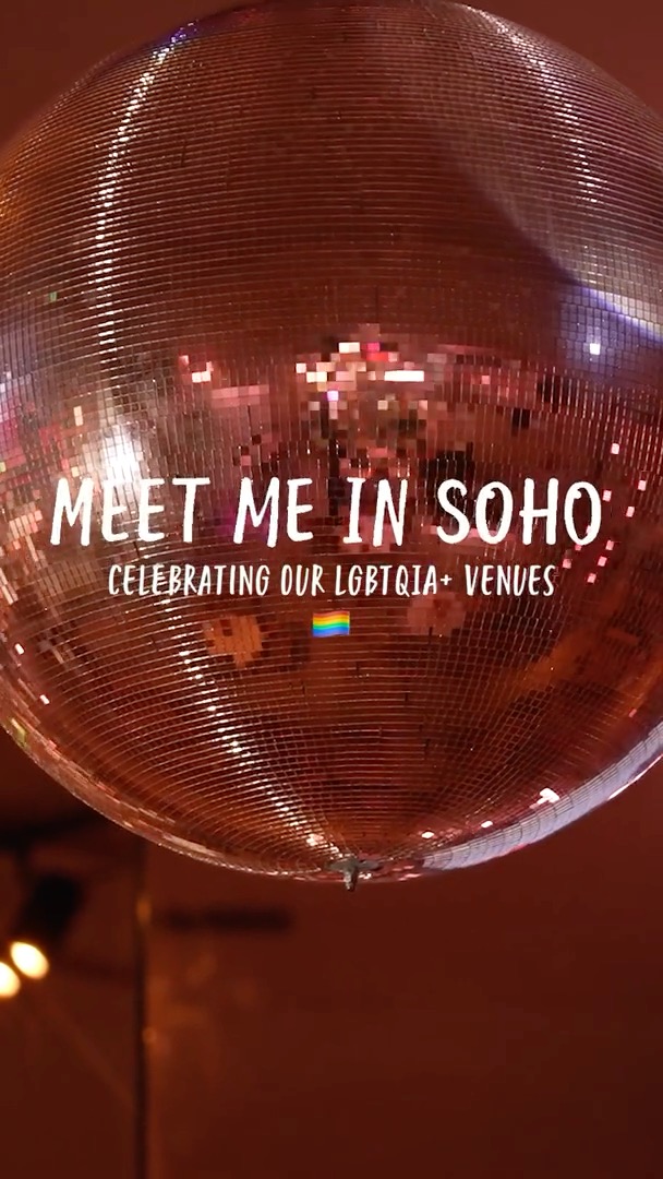 A disco ball reflects lights against a dark background, overlaid with white text reading "MEET ME IN SOHO: CELEBRATING OUR LGBTQIA+ VENUES" and a small rainbow flag emoji.