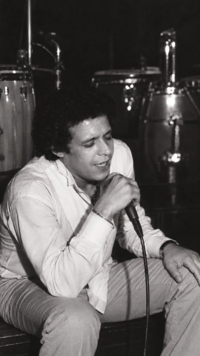 Chris_Montz's tweet photo. En noviembre de 1982, Héctor Lavoe aterrizó en Cali con una sola misión: desintoxicarse y huir del infierno que era Nueva York. El plan era aislarlo en un apartamento de lujo para limpiar su cuerpo, pero meter a Lavoe en la noche caleña fue apagar un incendio con gasolina...

El artífice del rescate fue el mítico empresario Larry Landa, quien lo instaló en un apartamento privado en la Torre Aristi, donde también vivía Alfredo de la Fe, su viejo amigo neoyorquino que tocaba en la discoteca Juan Pachanga. La orden era descansar y mantenerse limpio, pero Cali respiraba salsa las 24 horas, y el ambiente nocturno era intenso, así que aislar a Lavoe resultó imposible.

Héctor no tenía contratos firmados ni giras pactadas, pero la noche se lo tragó de inmediato. Dormía de día y vivía de noche. No era, además, un extraño en Cali, ya había visitado la ciudad años atrás y conocía bien el ambiente salsero. Frecuentaba Juan Pachanga con regularidad y, a veces por gusto y otras por insistencia de Landa, subía a cantar de forma improvisada. Lo que debía ser un santuario de desintoxicación se convirtió en una espiral de bohemia interminable. Su salud, lejos de mejorar, tocó fondo.

El retiro duró exactamente 71 días. Al ver que el ambiente lo estaba consumiendo por completo, Alfredo de la Fe intervino y convenció a Héctor de comprar un pasaje para regresar a Nueva York. Así, el 12 de enero de 1983, Lavoe subió al avión rumbo a Nueva York, cerrando el capítulo del viaje que buscaba salvarle la vida, pero que terminó hundiéndolo más en su laberinto.