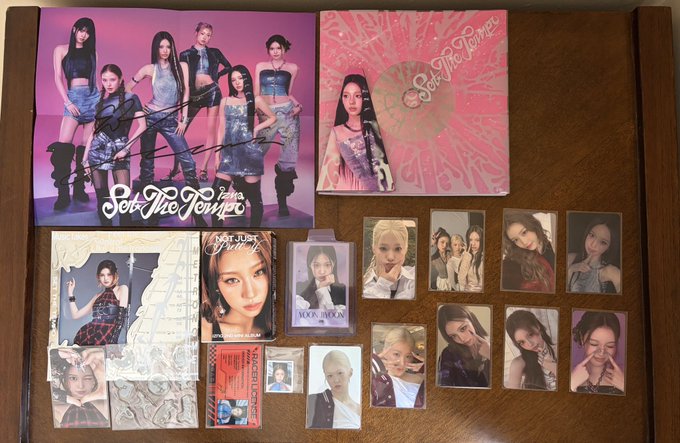 A collection of K-pop merchandise, including signed albums, photo cards, and memorabilia for the group See The Woman.