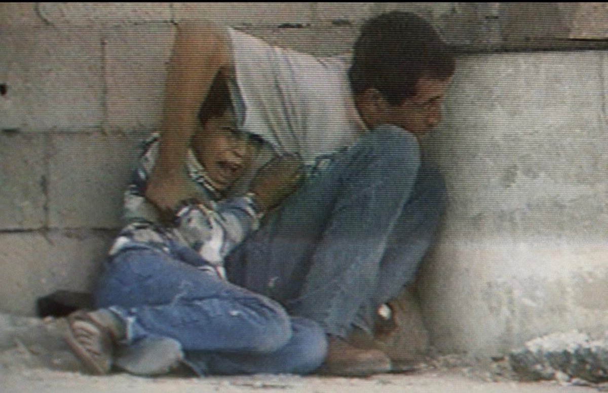 Palestine_UN's tweet photo. On this day 26 years ago, the world watched, as Jamal al-Durrah tried to protect his 12-year-old son Muhammad from Israeli bullets that rained down on them in Gaza for 40 minutes. Despite pleads, Israeli soldiers intentionally shot Muhammad in the stomach- whose final moments of fear and horror were caught on camera and streamed by France TV, and injured his father.

Muhammad became the defining and haunting image of the Second Intifada.