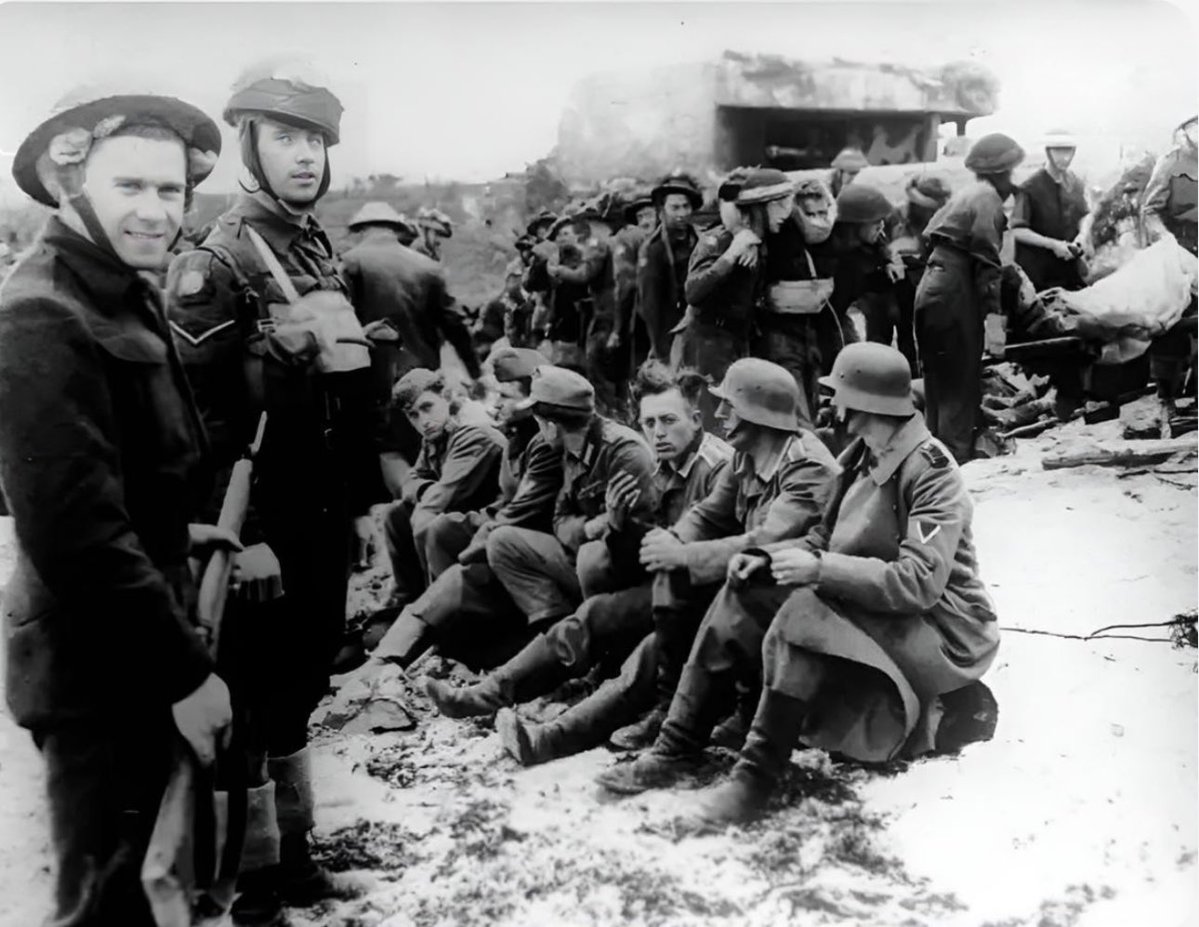 TheWorldatWar2's tweet photo. Canadian soldiers Guard German POWs on Juno Beach - Normandy, France, 6th June 1944 #juno #beach #dday #normandy #france #canadian #1940s #history https://t.co/gPNJyE2OPo
