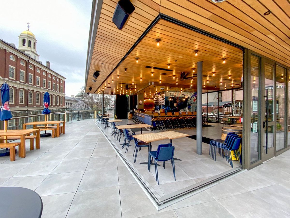 NanaWall's tweet photo. In a restaurant, seats are revenue. A wall that opens adds seats without adding square footage.  At @SamuelAdamsBeer Boston, #NanaWall doors create a true open corner bar opening onto Faneuil Hall terrace, keeping the light and the view when closed. @Bergmeyer @GilbaneBuilding https://t.co/zJpijzQD5p