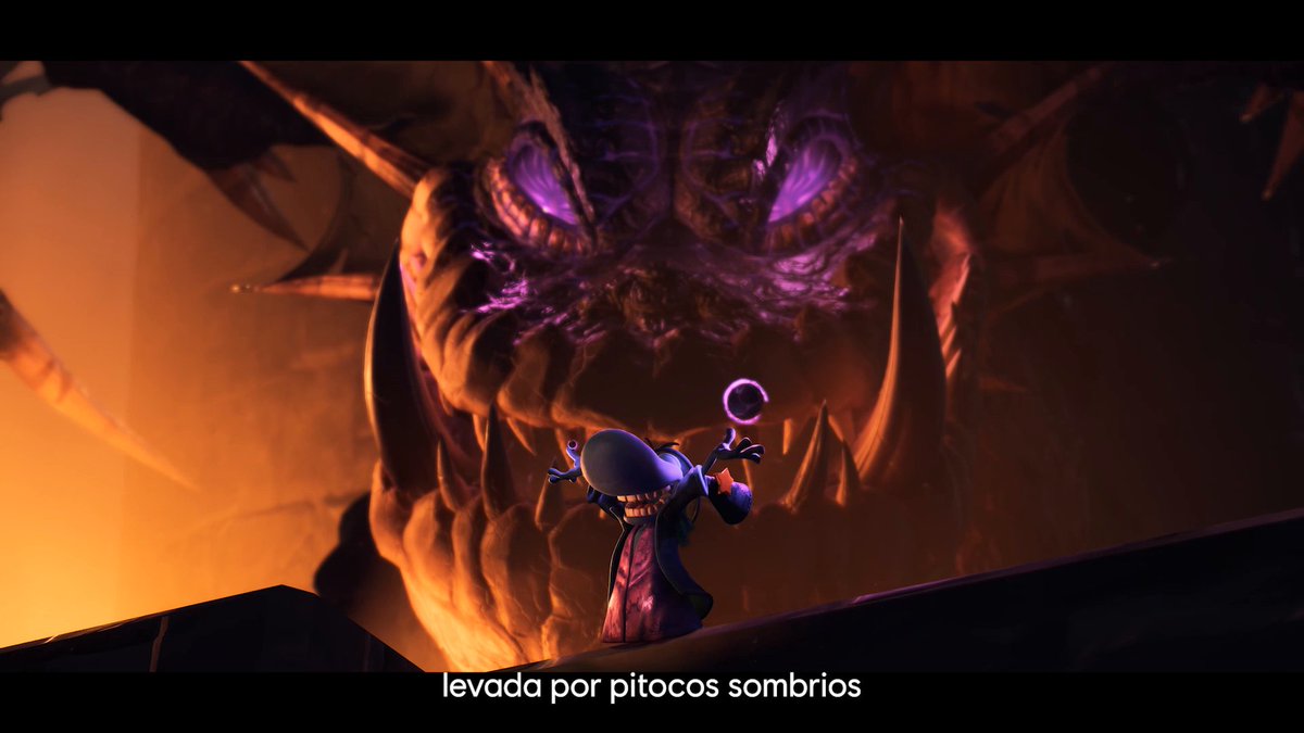 A dramatic video game scene showing a small hooded character with a crescent staff facing a massive, menacing purple-eyed monster in a fiery environment, with Portuguese subtitles reading 'levada por pitocos sombrios'.
