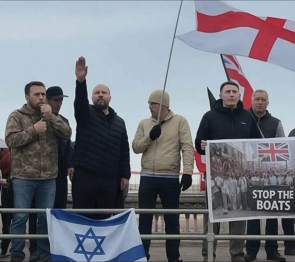 TheRealJamieKay's tweet photo. Just a totally normal hand gesture at a totally normal “Stop the Boats” protest. Nothing historically awkward about this image whatsoever. https://t.co/iM0yz1lRod