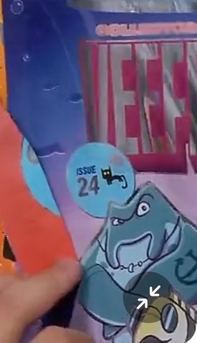 A close-up shows someone holding a comic book, focusing on the cover illustration of a gray shark-like creature with the text "ISSUE 24" displayed.