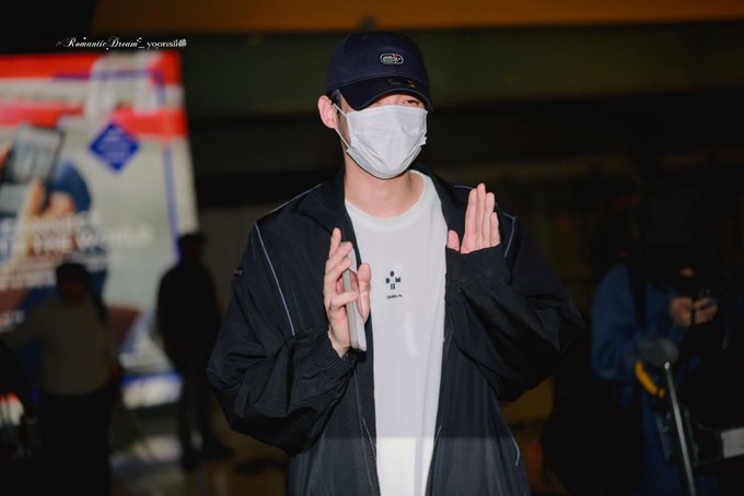 A man wearing a black cap, a white face mask, a black jacket, and a white t-shirt poses for the camera, holding up a phone. A watermark reads "Romantic_Dream2_vcerslab."