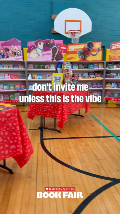 A school gymnasium set up as a Scholastic Book Fair with books displayed on shelves, tables covered in red patterned tablecloths, and overlaid text reading 'don't invite me unless this is the vibe' and 'SCHOLASTIC BOOK FAIR'.