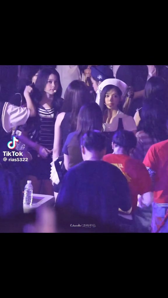A crowd of people, mostly young women, are gathered at an event, with one wearing a black and white striped outfit and headset, and a TikTok watermark reading '@rias5322' visible.