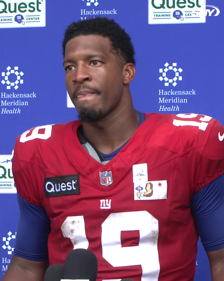 A New York Giants player wearing jersey #19, sponsored by Quest and Hackensack Meridian Health, speaks into a microphone during a press conference, with the accompanying quote from Jameis Winston discussing teammate J.J. McCarthy's curiosity and drive to make an impact with the team.