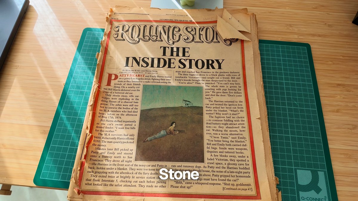 A worn copy of Rolling Stone magazine featuring the headline "THE INSIDE STORY" lies on a green cutting mat, displaying an article about Patty Hearst and the SLA.