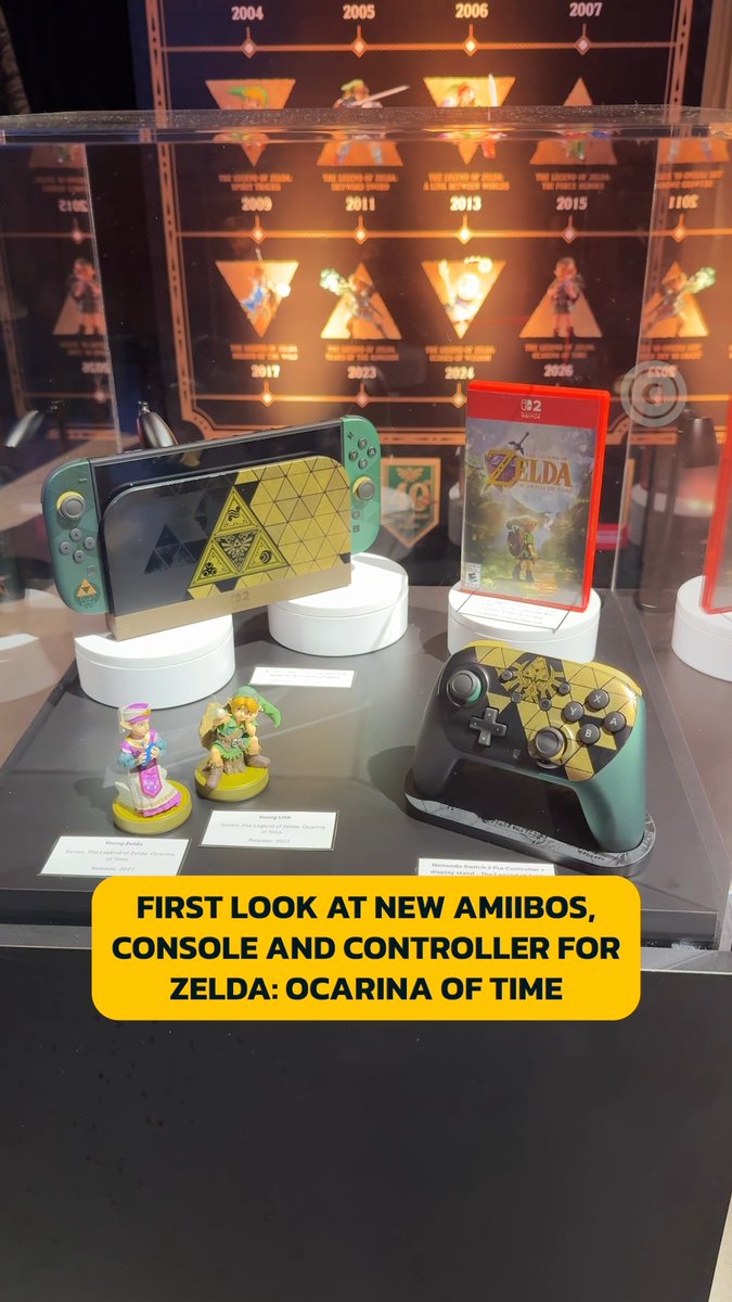 A display case showcases the Legend of Zelda: Ocarina of Time special edition Nintendo Switch 2 console, Pro Controller, game case, and amiibo figures (Young Zelda and Young Link), set against a backdrop featuring Zelda game release years from 2004 to 2026. The caption "FIRST LOOK AT NEW AMIIBOS, CONSOLE AND CONTROLLER FOR ZELDA: OCARINA OF TIME" appears at the bottom, directly corresponding to the post's mention of the Zelda-themed Switch 2 accessories.