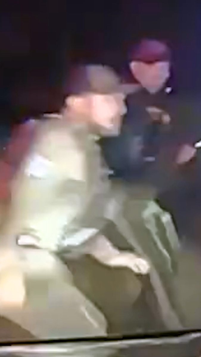 A blurry nighttime image showing what appears to be uniformed personnel, possibly law enforcement or military.