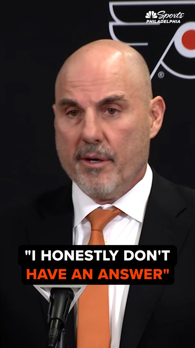 Rick Tocchet, dressed in a black suit with an orange tie, speaks at a press conference in front of a Philadelphia Flyers logo, with the on-screen caption reading "I HONESTLY DON'T HAVE AN ANSWER." The image visually captures his candid and frustrated reaction to the Flyers' lackluster performance against Pittsburgh, as referenced in the accompanying post about "disturbing plays."