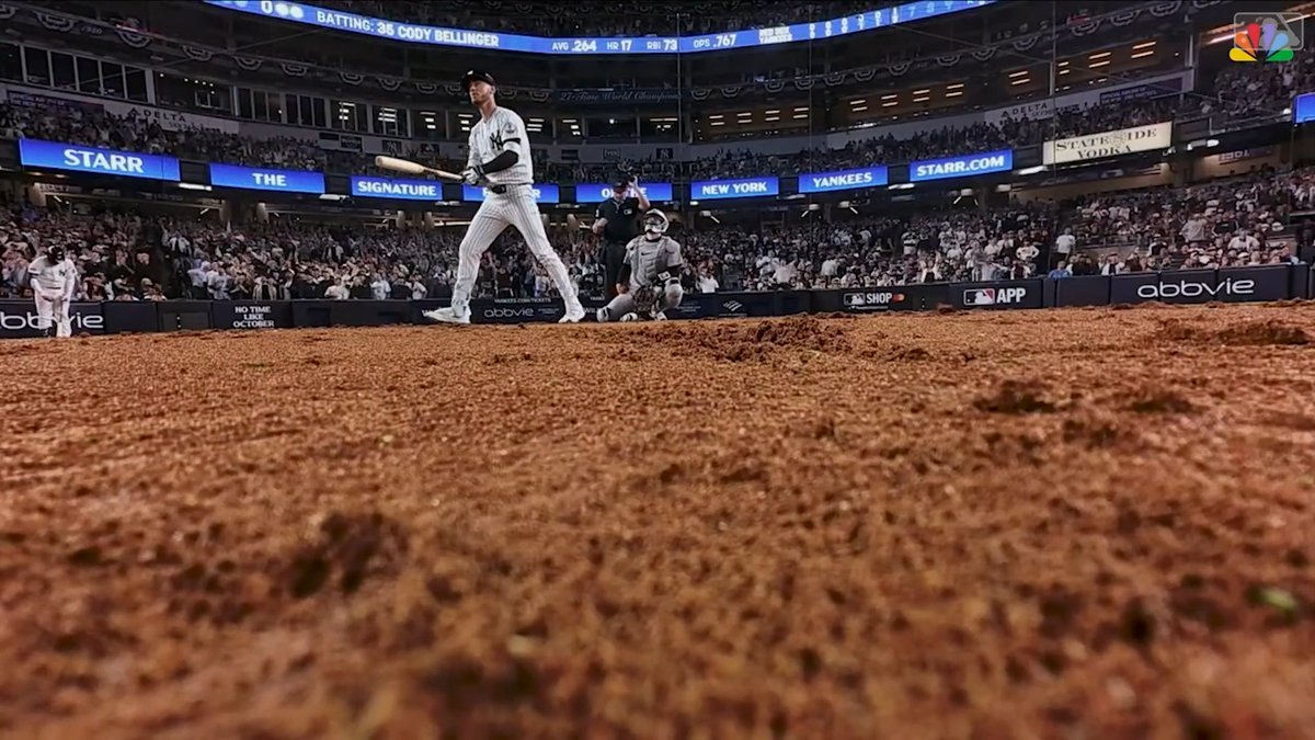 A low-angle shot from behind home plate shows New York Yankees batter Cody Bellinger (#35) at the plate, with the scoreboard displaying "BATTING: 35 CODY BELLINGER", "AVG .264", "HR 17", "RBI 73", "OPS .767", and advertisements for "STARR", "NEW YORK YANKEES", "DELTA", "STATE STREET VODKA", and "abbvie".