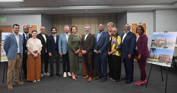 A group of men and women stand together for a photo.