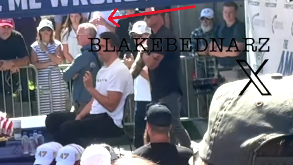 AlexandriaMcCue's tweet photo. Agreed. And it's like, what is this kid in this white t-shirt doing??? It looks like he's signaling out to the perimeter somewhere. 
To me, the first signal seems to indicate that the SM58 mic is now live. 
The second signal with the fists coming together seems to indicate that Charlie is about to grab the live mic with both fists in order to close the circuit. 
And the third signal, which would have been made right after Charlie's hands came together, could hypothetically indicate that the circuit has now been broken. 
This would make sense if Dan's signal at that same moment is, in fact, the signal that mirrors Rick's action of pulling the pin to break the circuit, which would then make the stage much less dangerous (but not quite "safe") for the security team in their little booties to rush in.