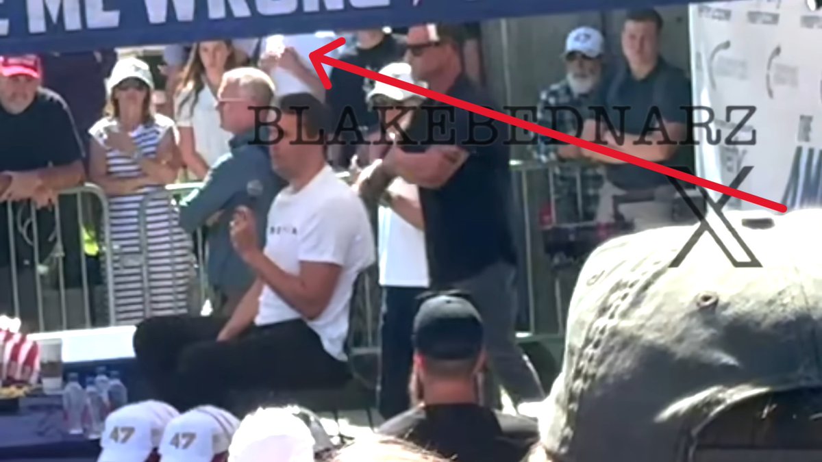 AlexandriaMcCue's tweet photo. Agreed. And it's like, what is this kid in this white t-shirt doing??? It looks like he's signaling out to the perimeter somewhere. 
To me, the first signal seems to indicate that the SM58 mic is now live. 
The second signal with the fists coming together seems to indicate that Charlie is about to grab the live mic with both fists in order to close the circuit. 
And the third signal, which would have been made right after Charlie's hands came together, could hypothetically indicate that the circuit has now been broken. 
This would make sense if Dan's signal at that same moment is, in fact, the signal that mirrors Rick's action of pulling the pin to break the circuit, which would then make the stage much less dangerous (but not quite "safe") for the security team in their little booties to rush in.