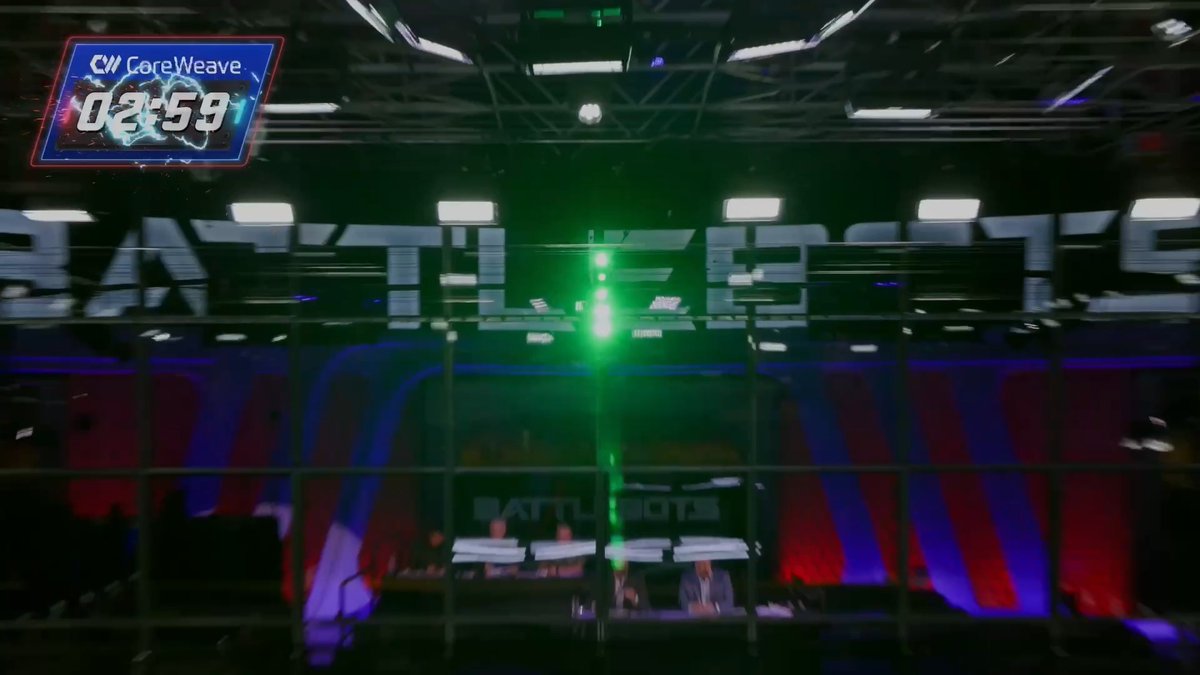 A blurry view of a 'BATTLEBOTS' arena set features a 'CoreWeave' timer graphic in the upper left corner displaying '02:59'.