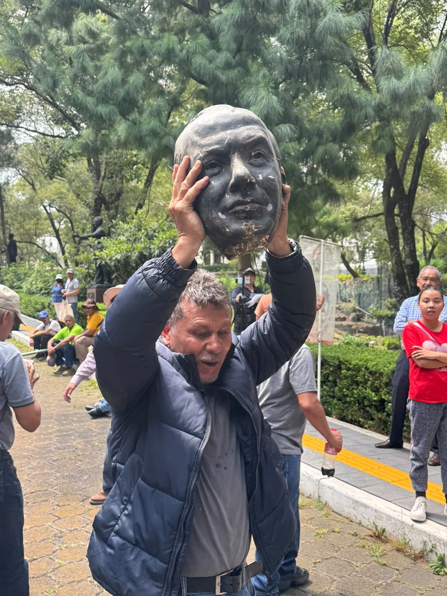 Diario_Info_'s tweet photo. Ex trabajadores de #LuzYFuerza cortaron la cabeza de la estatua de bronce del expresidente @FelipeCalderon, que estaba tirada desde hace más de un año, en la calzada de esculturas de Los Pinos, en protesta por su participación en el Foro América Libre 2026. Video: @ChilangoReport https://t.co/F70p2cmi7e