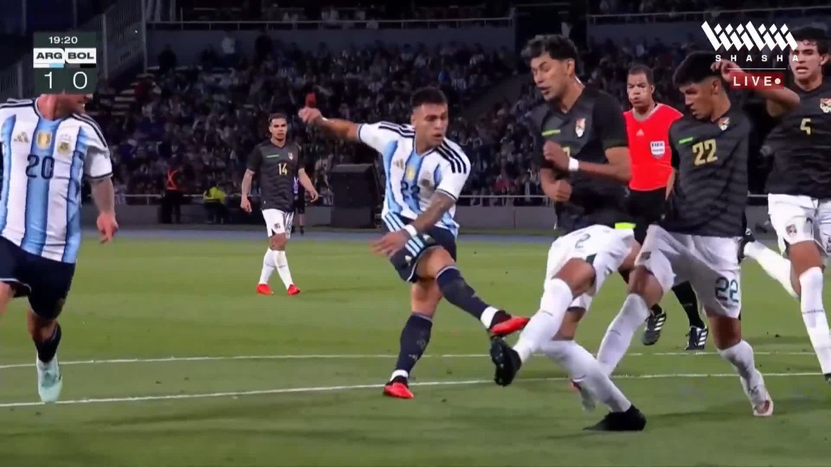 The scoreboard shows ARG 1 - 0 BOL at 19:20, capturing the moment of Lautaro Martínez's goal as he strikes the ball past the Bolivian goalkeeper for Argentina's opening score.