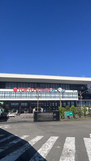 A photo of a building exterior with a "TOKYO SUMMERLAND" sign against a clear blue sky.