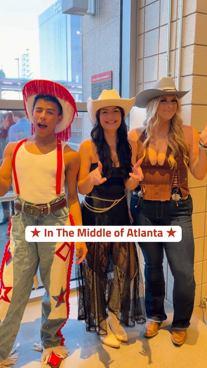 Three people in cowboy-themed costumes (including red chaps and western hats) with the caption '★ In The Middle of Atlanta ★' overlay.
