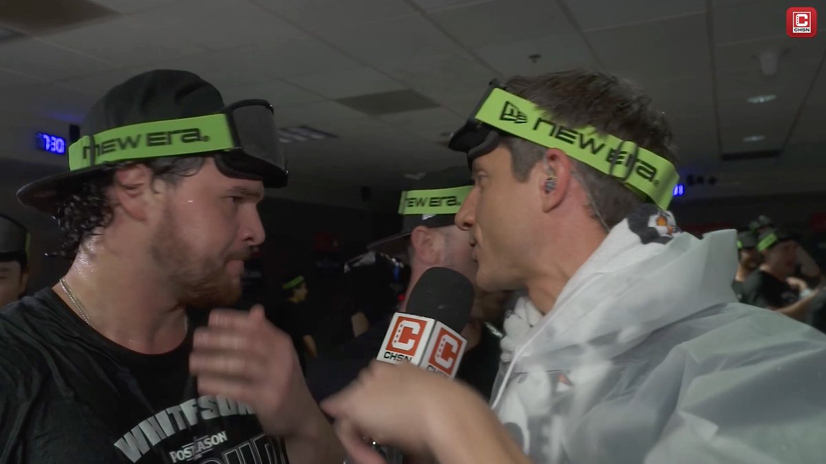 White Sox pitcher Mike Vasil is interviewed by CHSN in the locker room, both wearing bright green "New Era" headbands during a postseason celebration, with a clock reading 7:30 visible in the background. The scene captures the excitement of the moment, tying directly to the post's call to watch the interview.