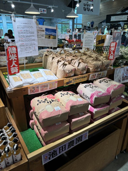 A Japanese rice and vegetable market display showcasing newly arrived bags of "ふっくりんこ" (Fukkurinko) and "ゆめぴりか" (Yumepirika) rice from 池田農園 (Ikeda Farm), with red signs announcing 新米入荷 (new rice arrival), matching the post's announcement of the new rice harvest and fresh seasonal vegetables.