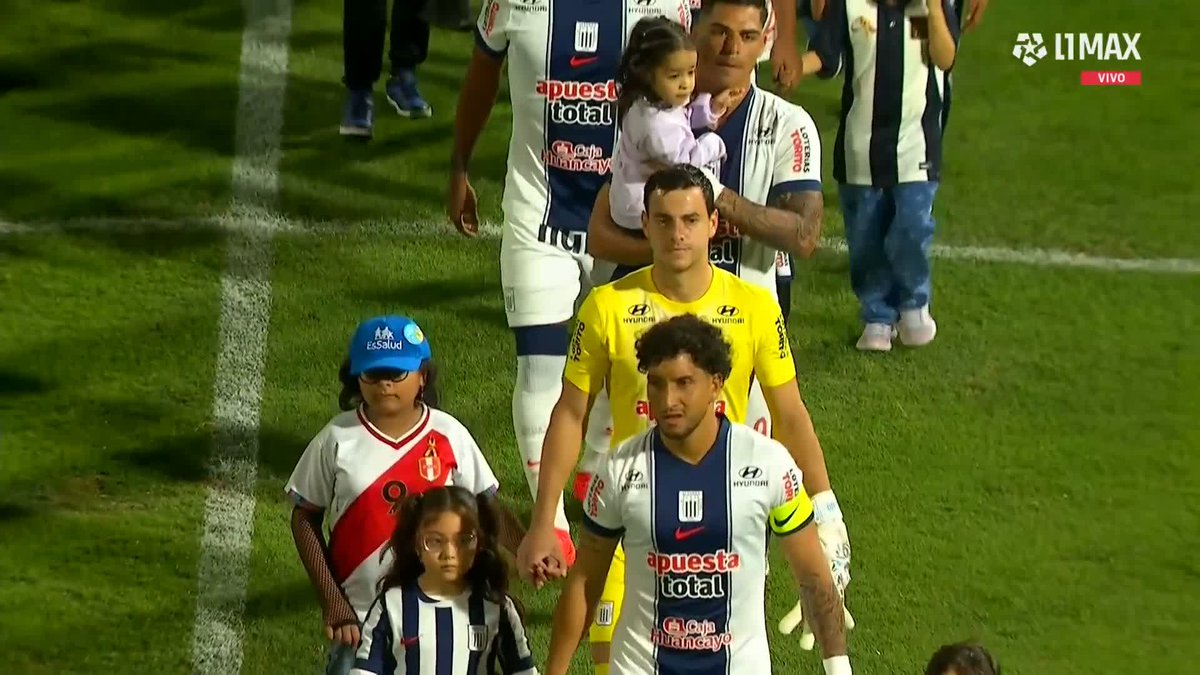 Alianza Lima players in blue and white striped jerseys with "Apuesta Total" and "Hyundai" sponsorships walk onto the field alongside children, while a goalkeeper in a yellow Hyundai jersey follows behind. The "L1MAX VIVO" broadcast graphic in the corner confirms this is a live stream of the international friendly match as the teams make their pre-game entrance.