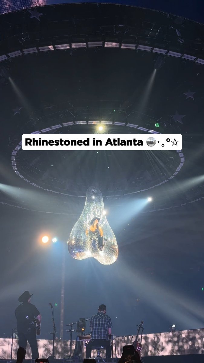 A concert stage in Atlanta featuring a performer inside a giant hanging disco ball-like structure with the caption 'Rhinestoned in Atlanta'.