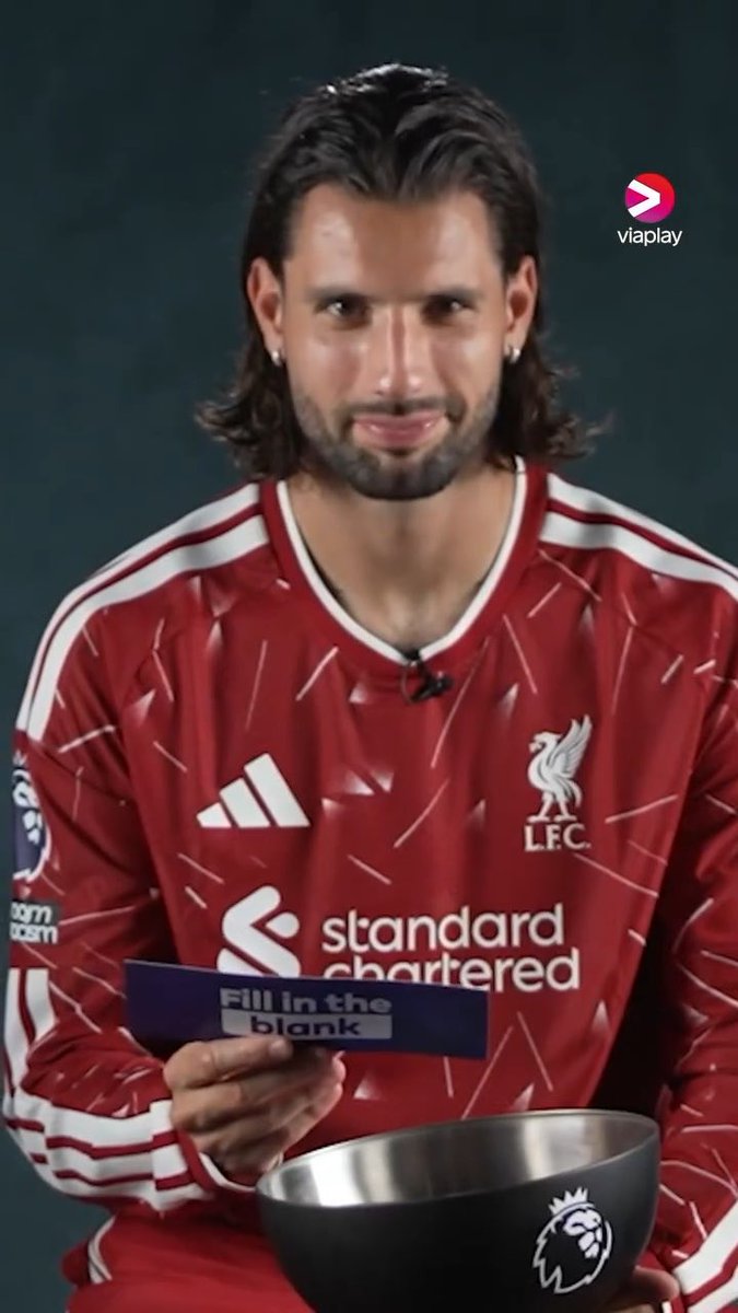 A screenshot from Viaplay shows Dominik Szoboszlai in a Liverpool FC "Standard Chartered" jersey participating in a Premier League "Fill in the blank" segment, holding a card over a Premier League-branded bowl, which relates to the post about him praising Florian Wirtz as the most skillful player on the ball.