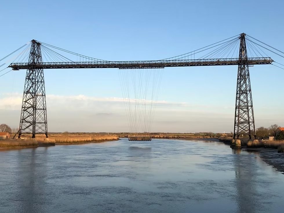 CeJourHistoire's tweet photo. Le pont qu'on voit au début du film Les Demoiselles de Rochefort existe toujours. Sa nacelle suspendue à des câbles transporte encore des passagers.

C'est le pont transbordeur du Martrou, entre Rochefort et Échillais, en Charente-Maritime. Le dernier pont transbordeur en service en France.

Le principe tient en deux lignes. Un tablier d'acier passe à 50 mètres au-dessus du fleuve, assez haut pour laisser passer les grands voiliers.

Sous ce tablier roule un chariot. Des câbles y accrochent la nacelle, qui glisse au ras de l'eau, d'une rive à l'autre.

L'ingénieur Ferdinand Arnodin le construit de 1898 à 1900.

4 pylônes de 66 mètres. Un tablier de 175 mètres.

Jusqu'en 1927, la nacelle est tirée par une machine à vapeur. Ensuite, par un moteur électrique.

À l'été 1966, le réalisateur Jacques Demy y tourne l'ouverture de son film. Les forains dansent sur le plancher de la nacelle, entre leurs camions.

L'année suivante, un nouveau pont ouvre juste en aval. Le transbordeur n'a plus de raison d'être.

En 1975, les crédits pour le démolir sont votés. Il est classé monument historique en 1976, juste à temps.

Restauré de 2016 à 2020, il a reçu un tablier neuf.

Aujourd'hui, la nacelle emporte jusqu'à 100 piétons et cyclistes par traversée.
