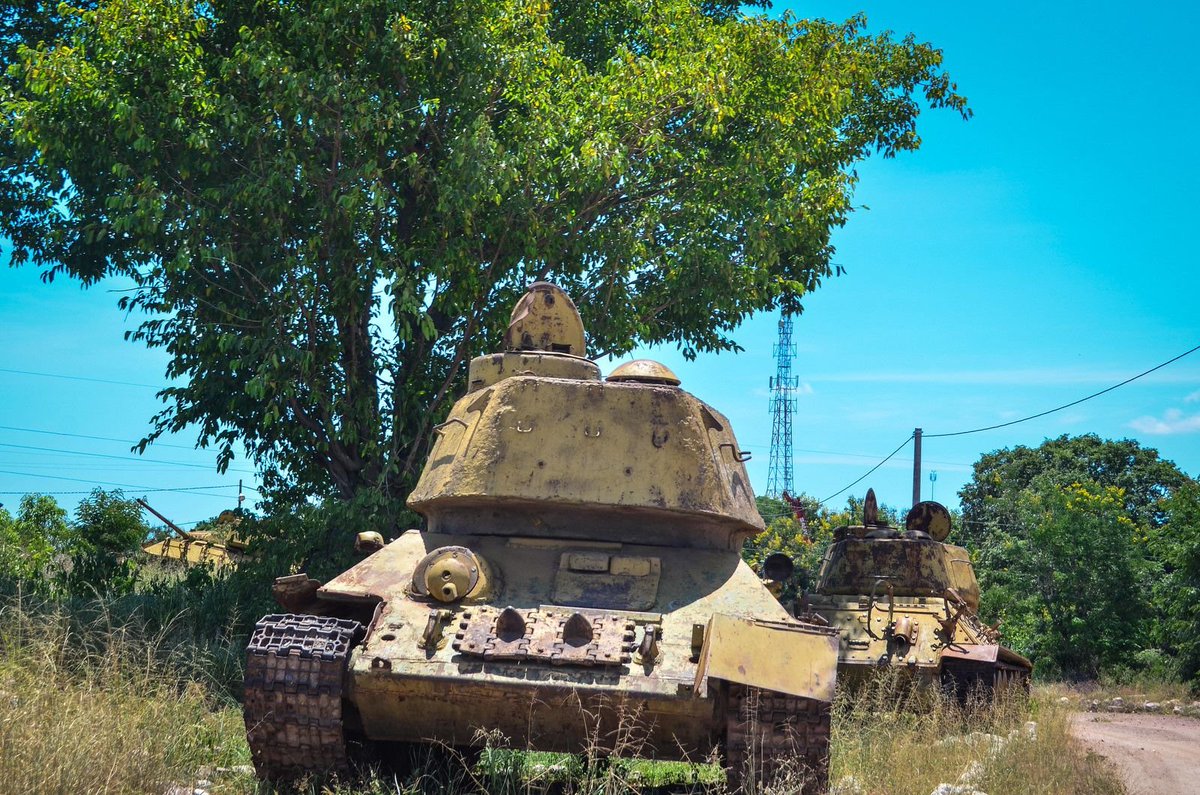T_90AK's tweet photo. T-34's chilling near a tree in Angola, 2014. https://t.co/lqhVKNQU6a