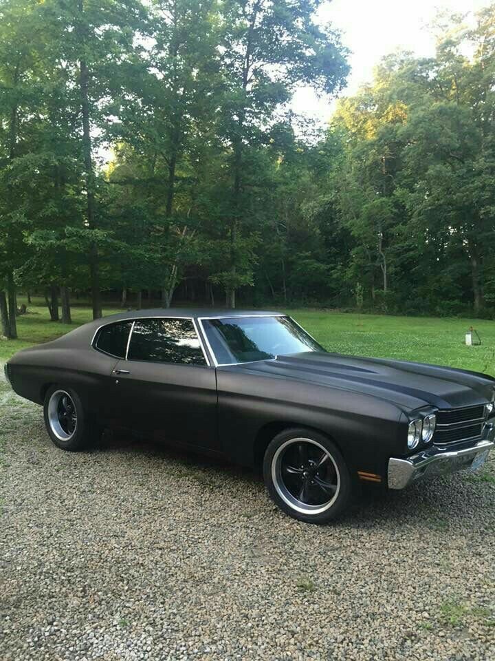 RestoMod804's tweet photo. Matte black 1970 Chevelle SS sitting low on black and chrome wheels, satin paint drinking the forest light - all muscle, no shine, just menace on gravel. https://t.co/eJQPMQCP22