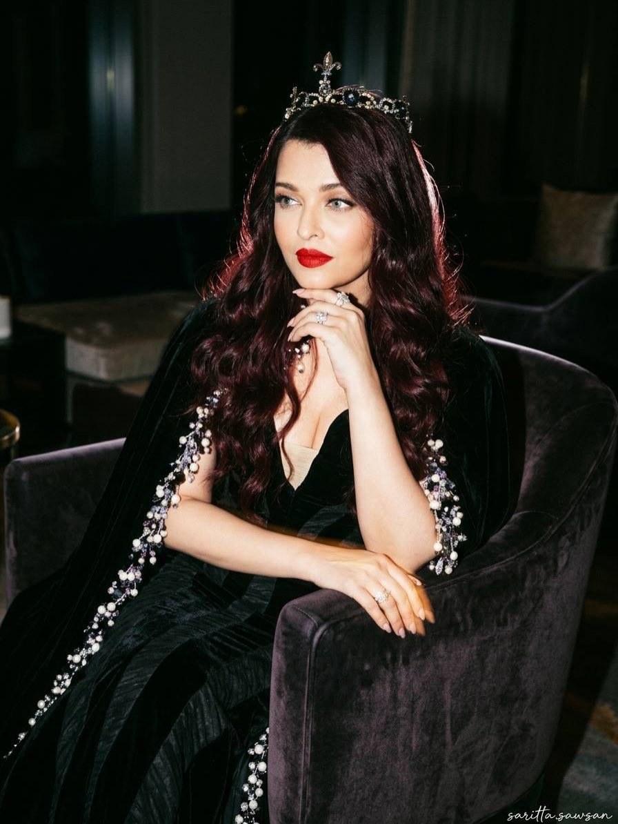 celeb124's tweet photo. Aishwarya Rai Bachchan closed L'Oréal Paris Le Défilé at Paris Fashion Week in a black velvet Yara Shoemaker couture gown with a crystal-and-pearl cape and diamond tiara. She debuted burgundy-red hair and a bold red lip for the regal runway moment in Paris. https://t.co/bFusMe3y6v